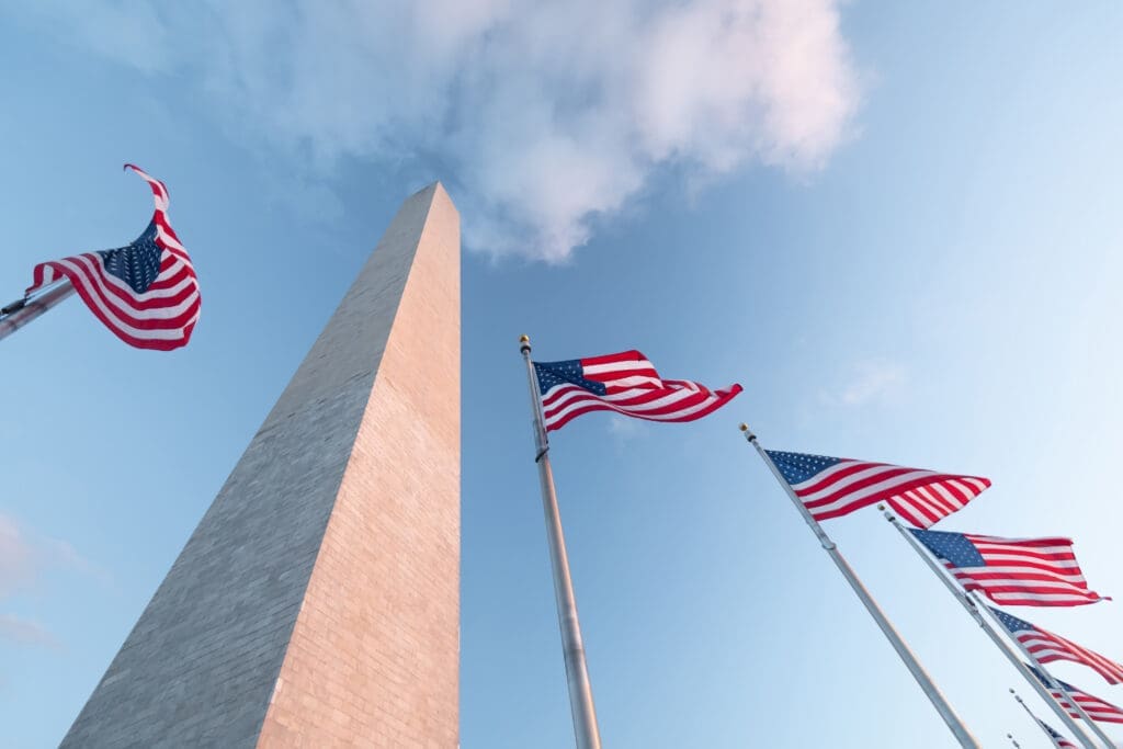 The Washington Monument seen from below with flags