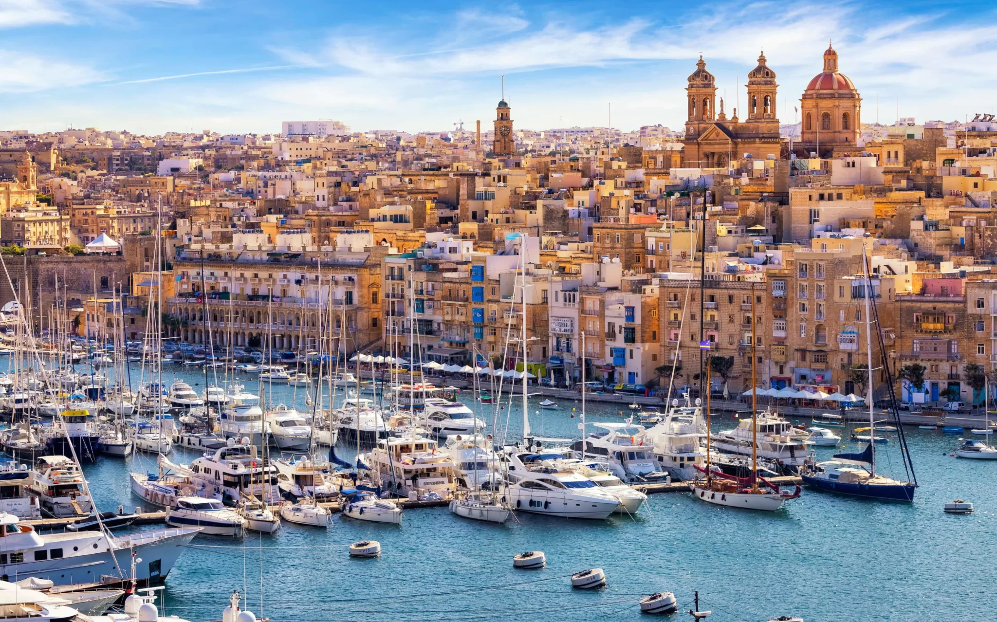Yachts moored below the churches and houses of Vittoriosa on the Grand Harbor, Malta